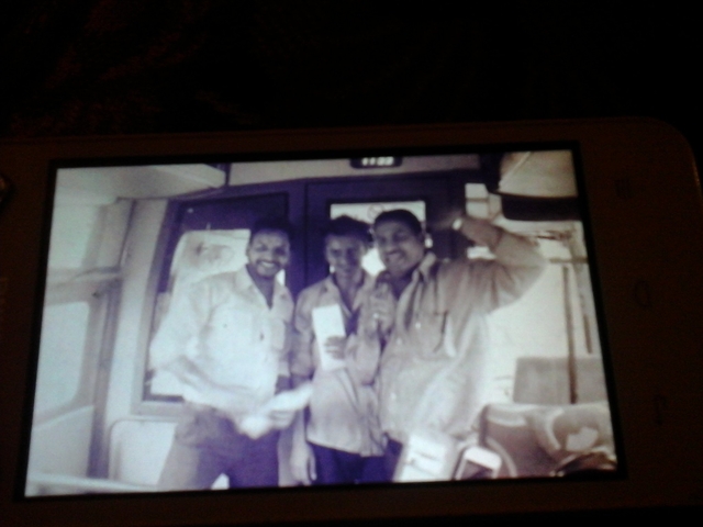 Grainy photo of three people in a vehicle.