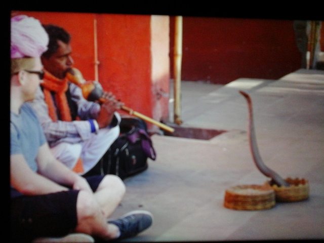 Snake charmer playing a musical instrument on a street.