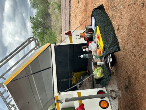       Picnic setup on the back of a vehicle in a natural setting.
  