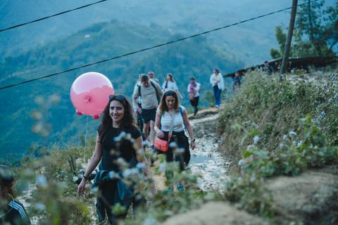       People hiking on a path surrounded by mountain ranges.
  