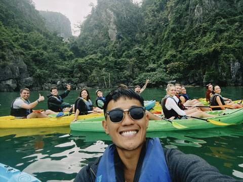       Group of friends kayaking on an emerald green water body.
  