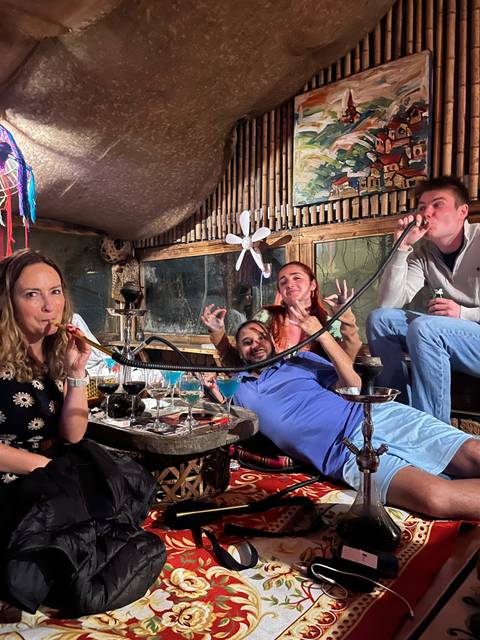       People enjoying hookah in a cozy indoor setting.
  