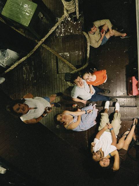       Group of people looking upwards on a wooden deck.
  