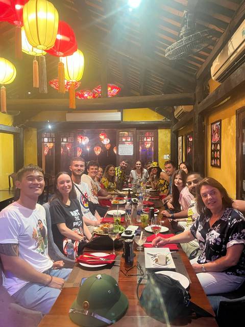       Large group dining together in a restaurant with lanterns.
  