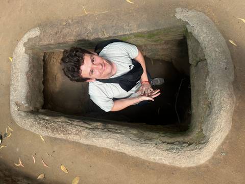       Person emerging from a narrow underground passage.
  