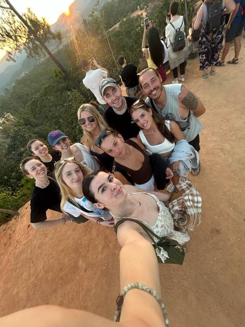       Group selfie of tourists on a rocky landscape in Thailand.
  