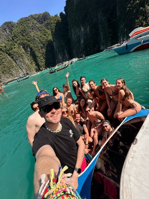       Tourists on a boat enjoying the water at a scenic location.
  