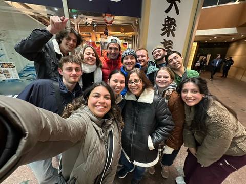 Group selfie inside a Japanese restaurant, with people smiling.