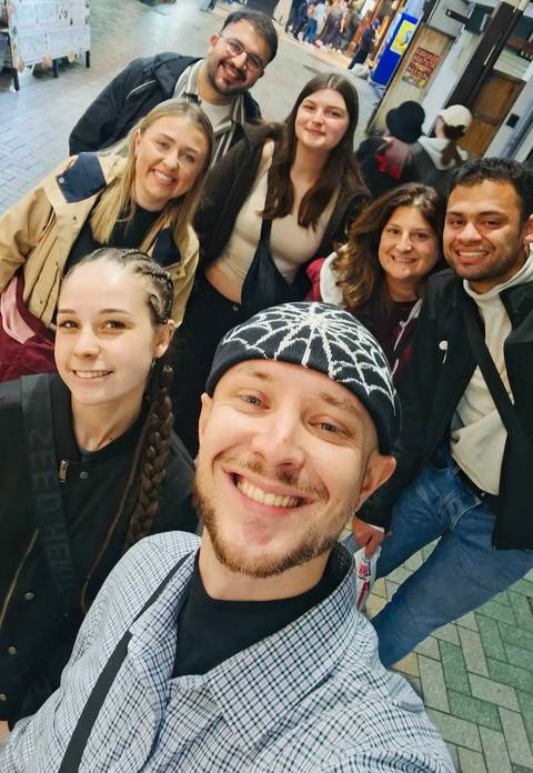 Close-up selfie of a group of friends inside a building.
