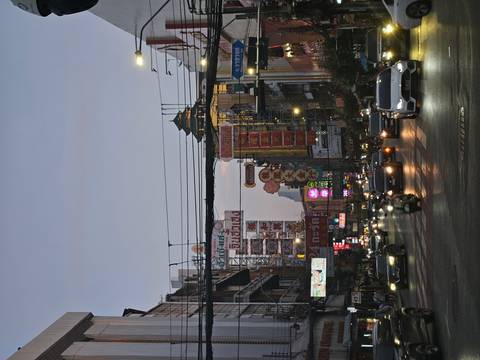       Busy street with signs and vehicles at dusk.
  