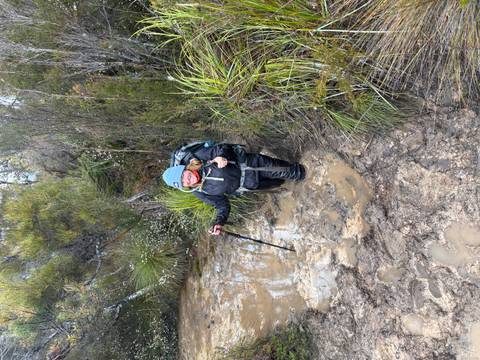 Person in hiking gear standing in mud.