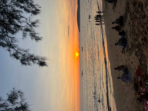       People watching a sunset on the beach.
  