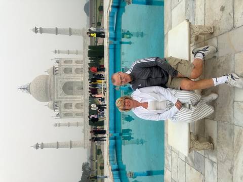 Two people sitting in front of the Taj Mahal.