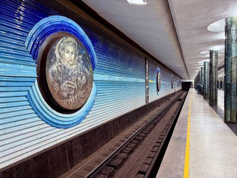 A metro station with decorative walls and tracks.