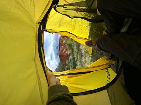       View from inside a tent facing mountains.
  