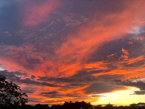 Vibrant sunset with dramatic clouds and orange hues.