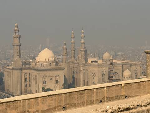       Historic mosque in Cairo with multiple minarets and domes.
  