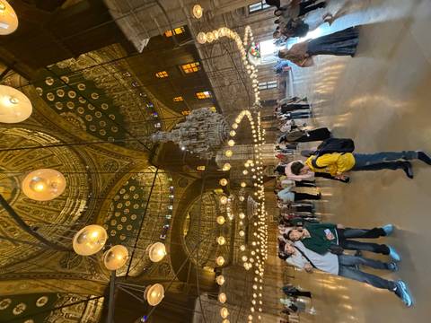 Ornate mosque interior with decorative ceilings and arches.