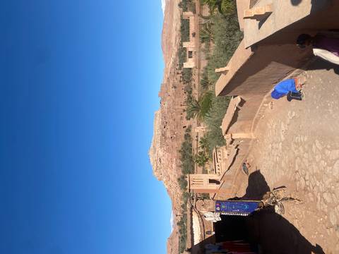 Children in the foreground with a historic kasbah in the background