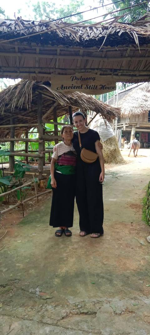       Person posing with an elderly woman in a rural setting.
  