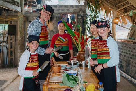       Group of people smiling and posing during a cooking class.
  