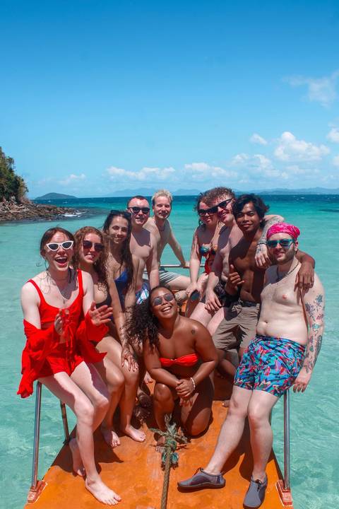 Group of people on a boat with turquoise water in the background.