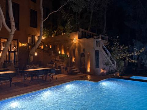       Night view of a poolside in a resort with atmospheric lighting.
  