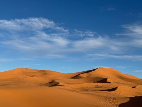 Sand dunes under a blue sky.