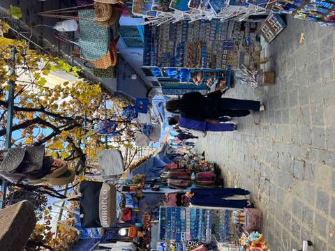 Tourists walking through a lively market alley.