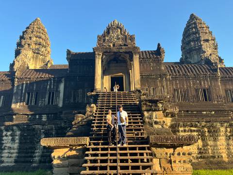 People climbing stairs to ancient temple at Angkor Wat.