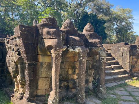       Ancient elephant statues at ruins with stairs.
  