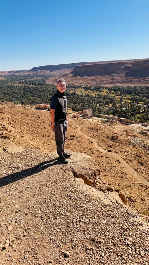 A person standing on a hill overlooking a village.