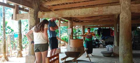       A person observing traditional weaving in a rustic setting.
  