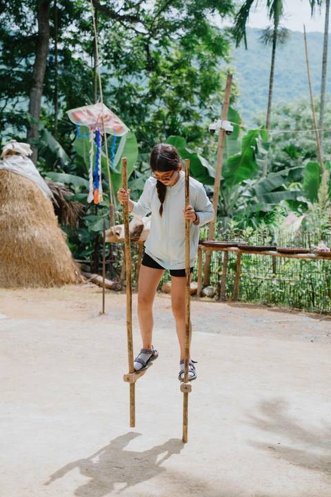       A woman engaged in a traditional stilt activity.
  