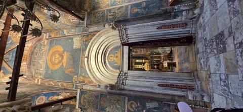       Interior of a church with ornate religious paintings and architecture.
  