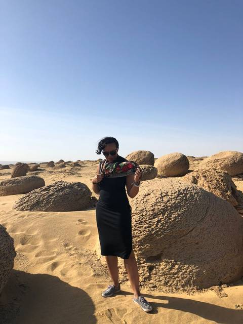       Person posing in the desert with rock formations.
  