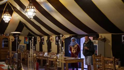       Inside a traditional tent with two people, decorated with local artifacts.
  