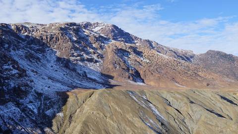       Snow-capped mountain range under a blue sky.
  
