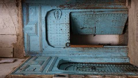       Old blue wooden doors in a narrow street.
  