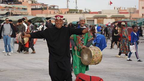       Traditional Moroccan performers in colorful attire with drums.
  