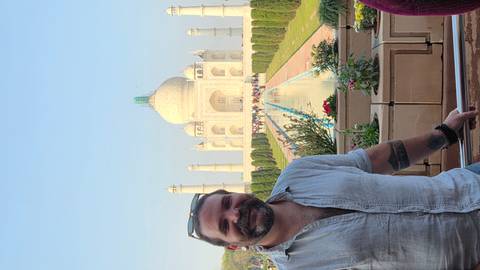 Person standing with the Taj Mahal in the background.