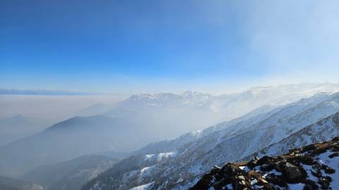 Scenic view of snow-capped mountains under a bright blue sky.