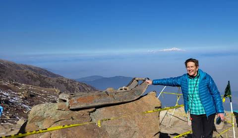 Tourist posing with a mountain view in the background.