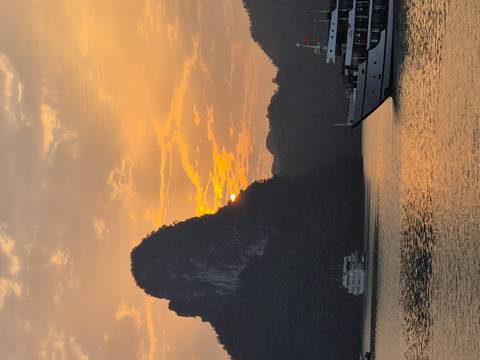       Sunset view over Halong Bay with boats.
  