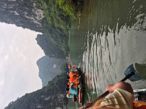 People boating through a river in a mountainous area.