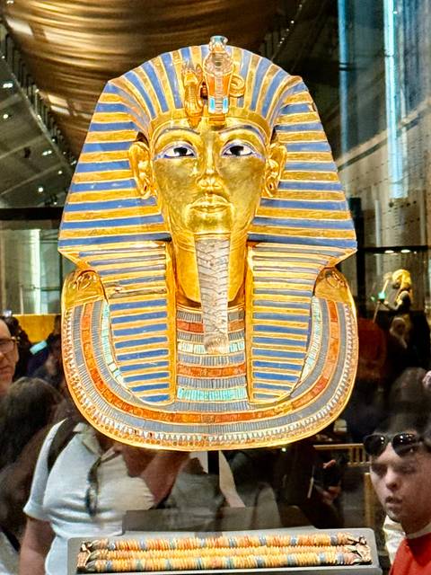       Tutankhamun's golden death mask on display in a museum.
  