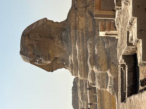       The Great Sphinx of Giza with ancient monuments in the background.
  