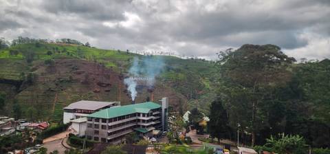 Smoke rising from a factory in a hilly area
