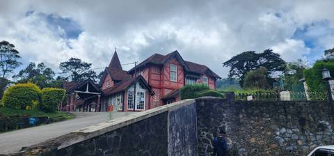 Country house with a red brick facade surrounded by hills