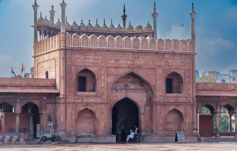 Red Fort entrance with decorative arches and people entering.